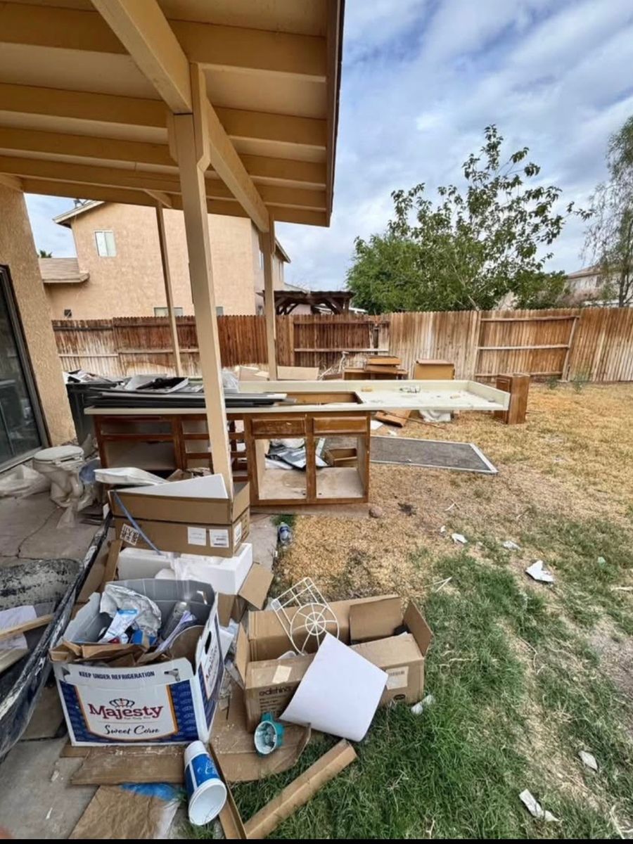 Backyard full of old cabinets and debris before a cleanout